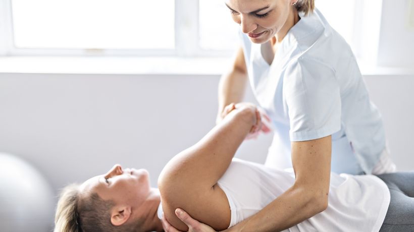 Patient stretching with physical therapist