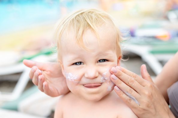 Baby with suncreen on cheeks